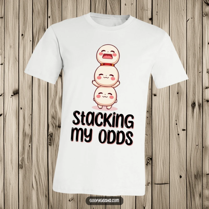 Funny t-shirt depicting a small character balancing a huge stack of Daruma dolls, illustrating a humorous and relatable challenge.